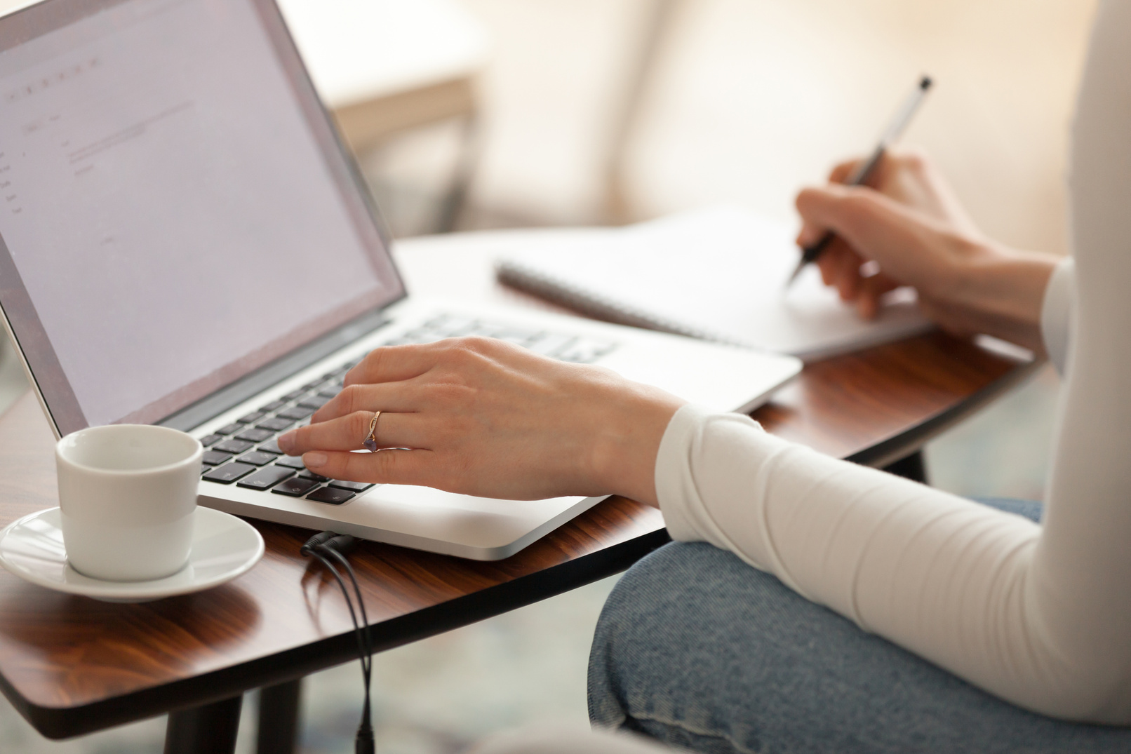 Woman student making notes studying learning online with computer